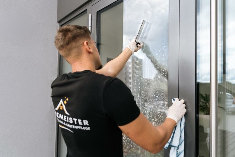 Professioneller Fensterputzer von Glanzmeister bei der streifenfreien Fensterreinigung mit Abzieher.