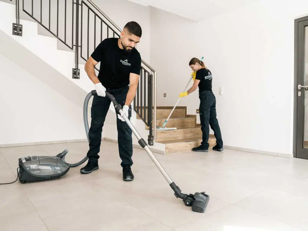 Glanzmeister-Team bei der professionellen Unterhaltsreinigung – Staubsaugen und Bodenwischen in einem Treppenhaus im Kundengebäude.